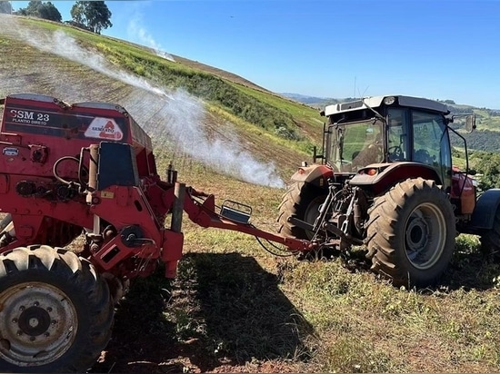 Un agriculteur travaille sur la pente d'un champ dans